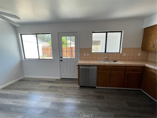 1935 W Santa Ana Ave, Fresno, CA 93705 - kitchen featuring stainless steel dishwasher, tile countertops, dark wood finished floors, and tasteful backsplash