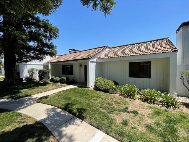 1935 W Santa Ana Ave, Fresno, CA 93705 - mediterranean / spanish-style house with a tiled roof, a chimney, and a front yard