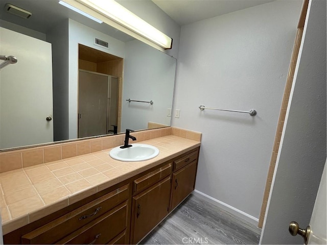 1935 W Santa Ana Ave, Fresno, CA 93705 - bathroom with wood finished floors, vanity, and a shower with shower door