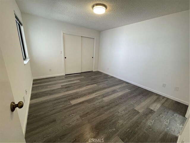 1935 W Santa Ana Ave, Fresno, CA 93705 - unfurnished bedroom with dark wood-style floors, a textured ceiling, and a closet