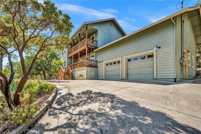 19072 Redbud Rd, Hidden Valley Lake, CA 95467 - view of side of property with a balcony, driveway, a garage, and stairs