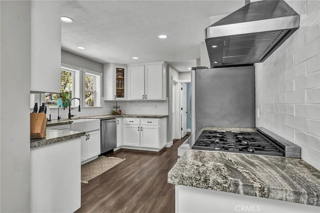 19072 Redbud Rd, Hidden Valley Lake, CA 95467 - kitchen with wall chimney range hood, appliances with stainless steel finishes, tasteful backsplash, dark stone countertops, and white cabinetry