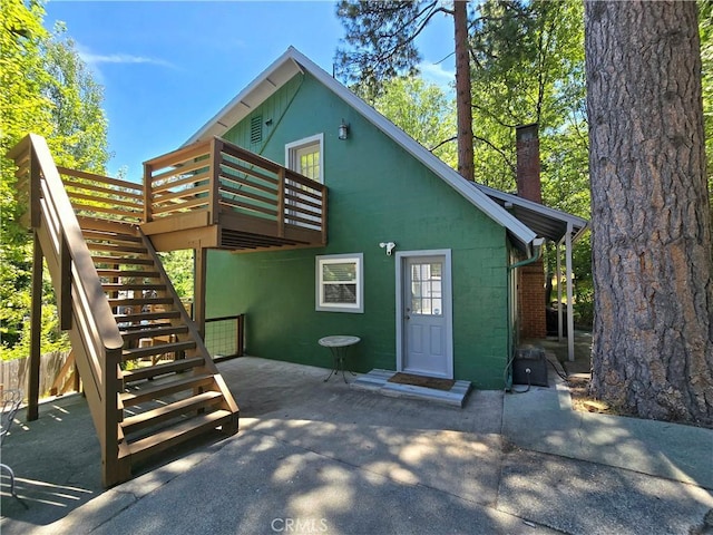 2445 Spring Dr, Running Springs, CA 92382 - rear view of property with a wooden deck, concrete block siding, a patio area, and stairway