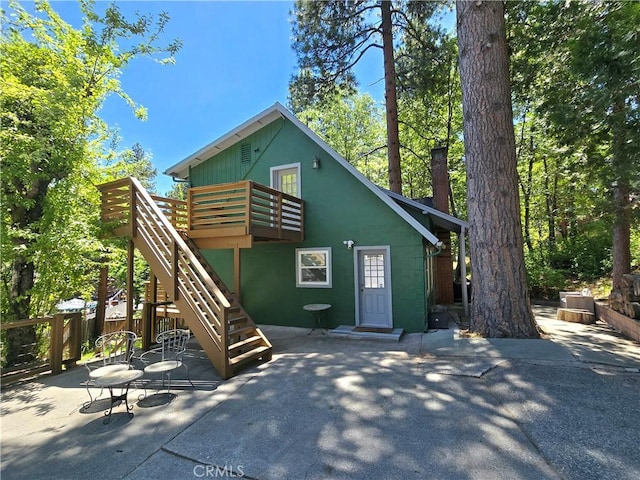 2445 Spring Dr, Running Springs, CA 92382 - view of front of property with a patio area, a deck, a chimney, and stairway