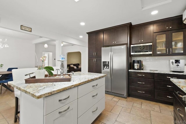 6038 Bradford St, San Diego, CA 92115 - kitchen with appliances with stainless steel finishes, recessed lighting, white cabinetry, dark brown cabinetry, and backsplash
