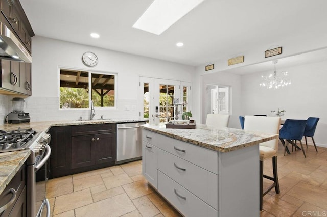 6038 Bradford St, San Diego, CA 92115 - kitchen featuring stainless steel appliances, a breakfast bar, stone tile flooring, recessed lighting, and backsplash