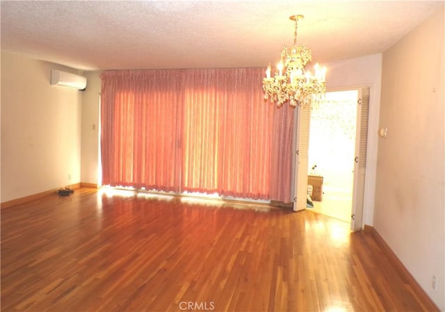 662 Kempton Ave, Monterey Park, CA 91755 - empty room featuring a wall unit AC, wood finished floors, a chandelier, and a textured ceiling