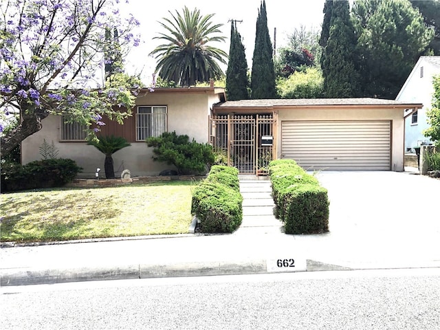 662 Kempton Ave, Monterey Park, CA 91755 - view of front facade featuring stucco siding, an attached garage, and concrete driveway