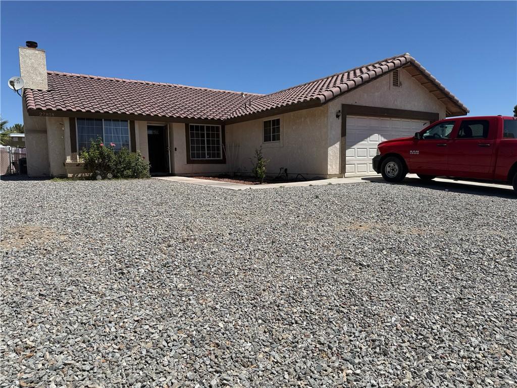 27818 Hummingbird Ln, Helendale, CA 92342 - ranch-style home featuring a garage, a chimney, a tiled roof, and stucco siding