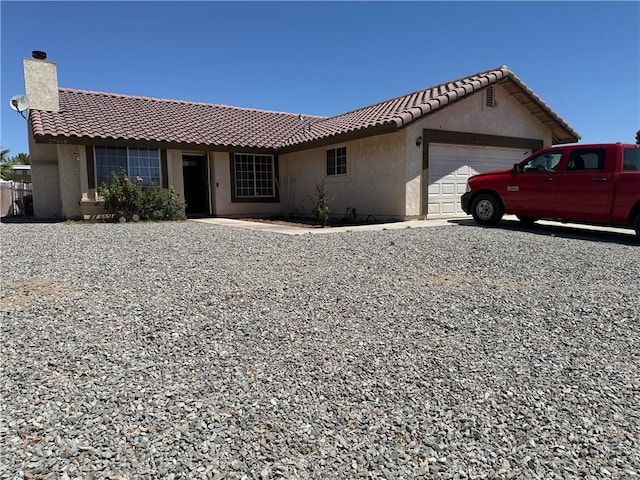 27818 Hummingbird Ln, Helendale, CA 92342 - ranch-style home featuring a garage, a chimney, a tiled roof, and stucco siding