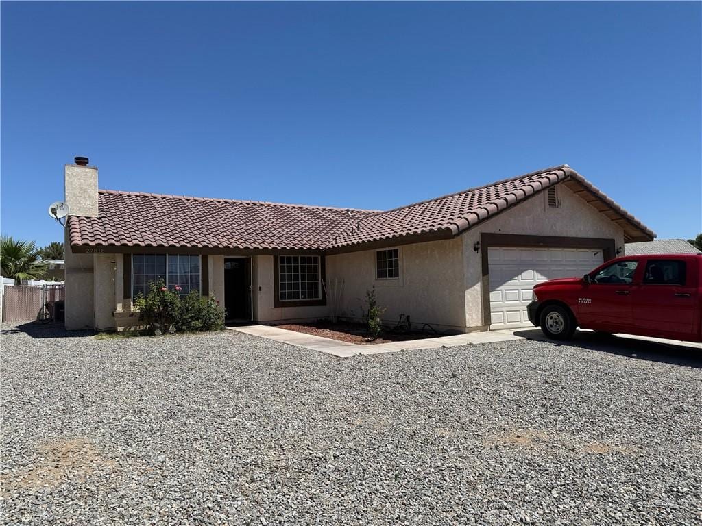 27818 Hummingbird Ln, Helendale, CA 92342 - ranch-style home with a garage, a tile roof, stucco siding, and a chimney