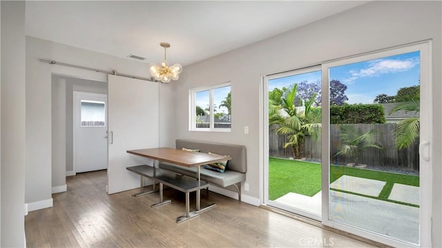 5202 E Conant St, Long Beach, CA 90808 - dining space with a chandelier, wood finished floors, healthy amount of natural light, and a barn door