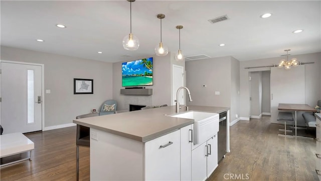 5202 E Conant St, Long Beach, CA 90808 - kitchen featuring stainless steel dishwasher, a kitchen island with sink, dark wood-style flooring, open floor plan, and decorative light fixtures