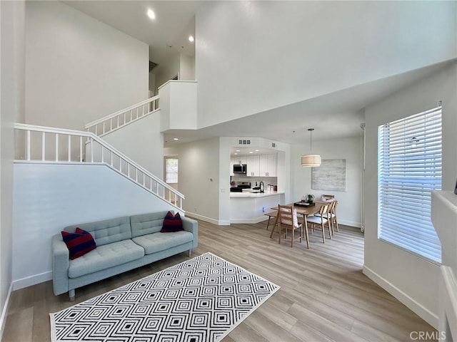 13390 Savanna, Tustin, CA 92782 - living area with stairway, light wood-style flooring, recessed lighting, and a high ceiling