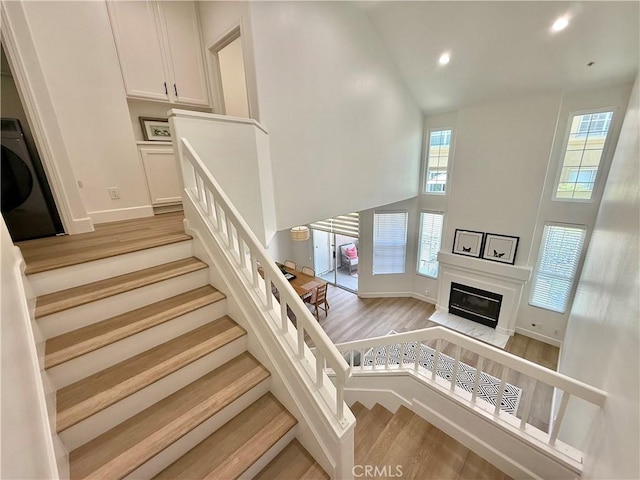 13390 Savanna, Tustin, CA 92782 - stairway featuring high vaulted ceiling, wood finished floors, recessed lighting, and a glass covered fireplace