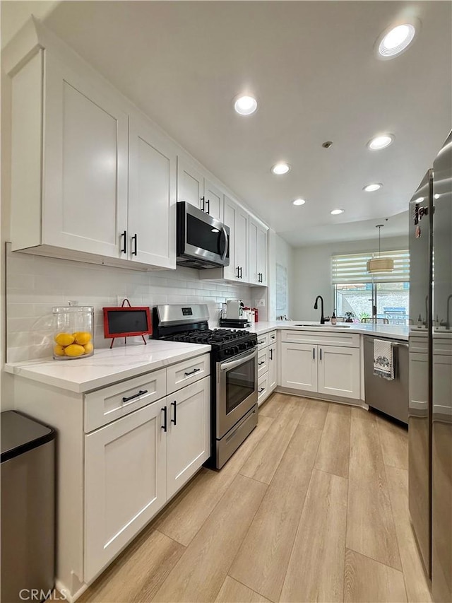 13390 Savanna, Tustin, CA 92782 - kitchen with appliances with stainless steel finishes, light wood-style floors, white cabinetry, backsplash, and recessed lighting