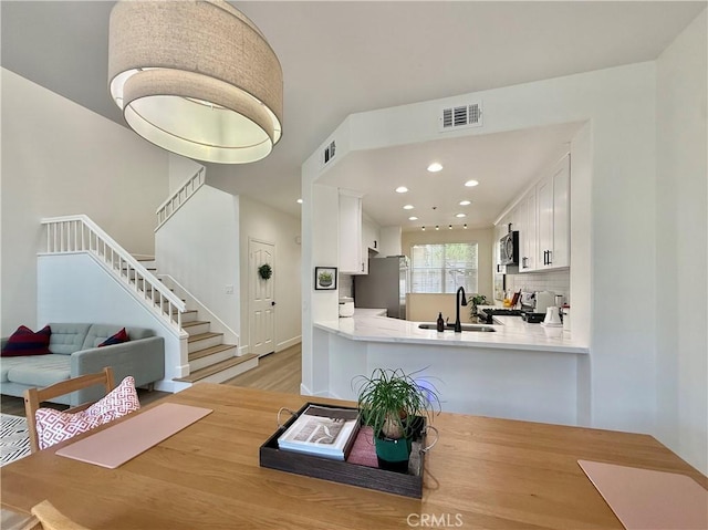 13390 Savanna, Tustin, CA 92782 - kitchen featuring stainless steel microwave, light wood finished floors, light countertops, white cabinetry, and recessed lighting