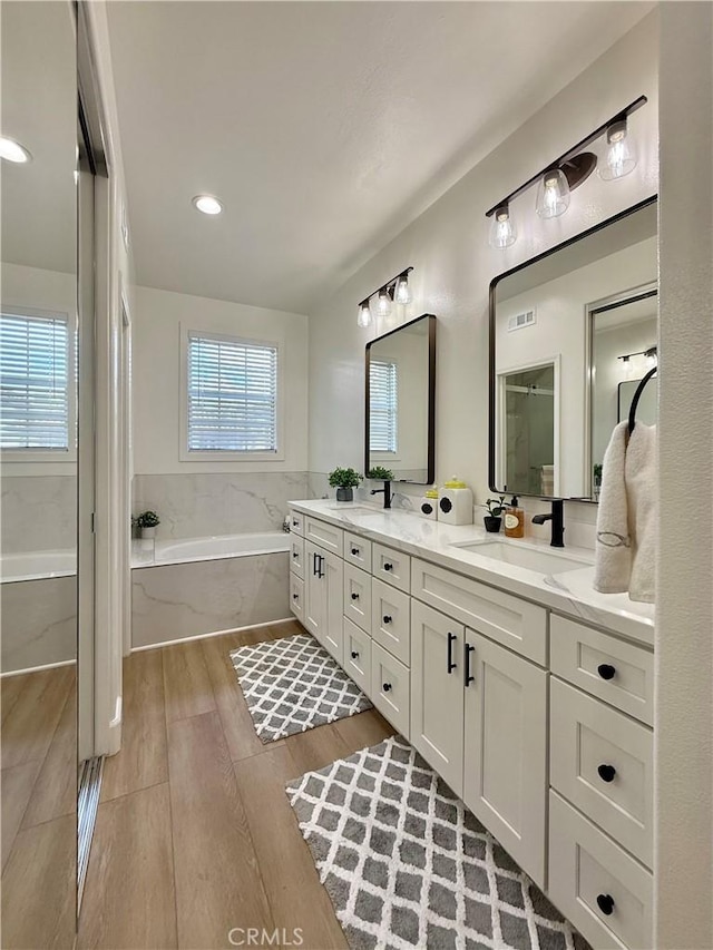13390 Savanna, Tustin, CA 92782 - bathroom featuring a garden tub, double vanity, wood finished floors, and recessed lighting