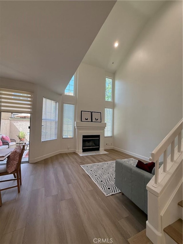 13390 Savanna, Tustin, CA 92782 - living room with high vaulted ceiling, wood finished floors, stairs, a fireplace with flush hearth, and recessed lighting
