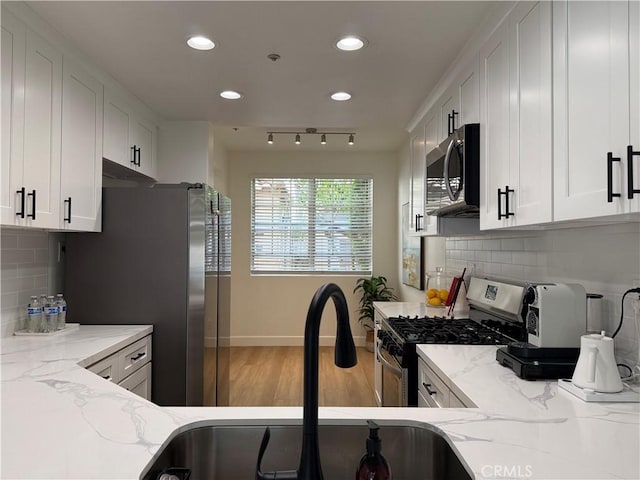 13390 Savanna, Tustin, CA 92782 - kitchen with appliances with stainless steel finishes, recessed lighting, white cabinets, light stone countertops, and wood finished floors