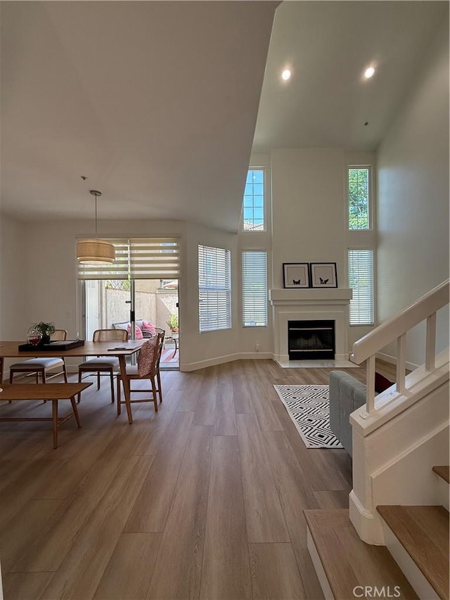 13390 Savanna, Tustin, CA 92782 - living room featuring light wood-style flooring, a glass covered fireplace, recessed lighting, and high vaulted ceiling