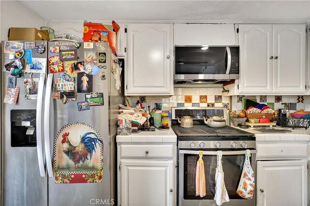 12161 Napoli Dr, Cerritos, CA 90703 - kitchen featuring appliances with stainless steel finishes, tile countertops, and white cabinetry