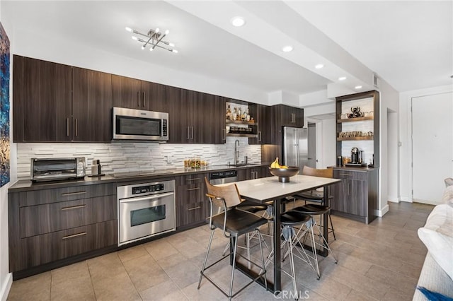 1131 Alta Loma Rd Unit 207, West Hollywood, CA 90069 - kitchen with open shelves, appliances with stainless steel finishes, dark countertops, dark brown cabinets, and decorative backsplash