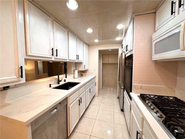 28004 Western Ave S Unit 121, San Pedro, CA 90732 - kitchen with appliances with stainless steel finishes, light tile patterned floors, recessed lighting, light stone counters, and white cabinetry