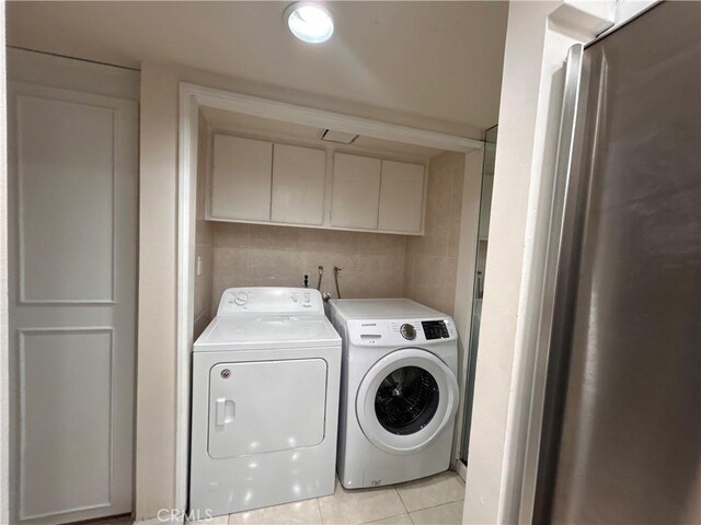 28004 Western Ave S Unit 121, San Pedro, CA 90732 - washroom with washing machine and dryer, cabinet space, and light tile patterned floors