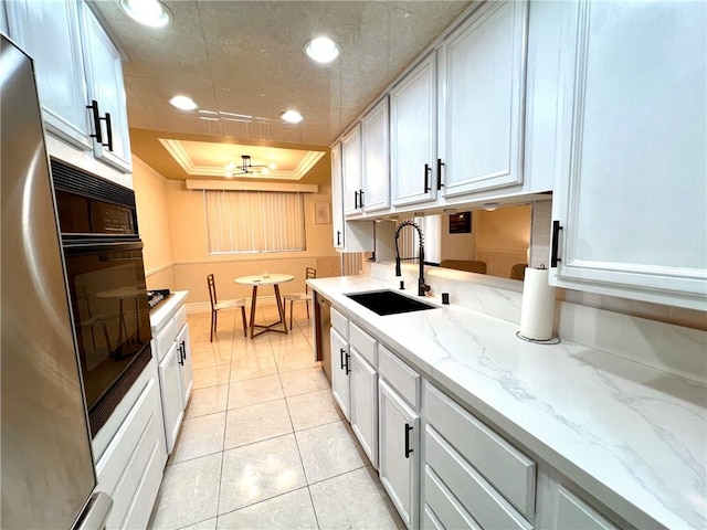 28004 Western Ave S Unit 121, San Pedro, CA 90732 - kitchen with oven, white cabinets, a raised ceiling, refrigerator, and a ceiling fan
