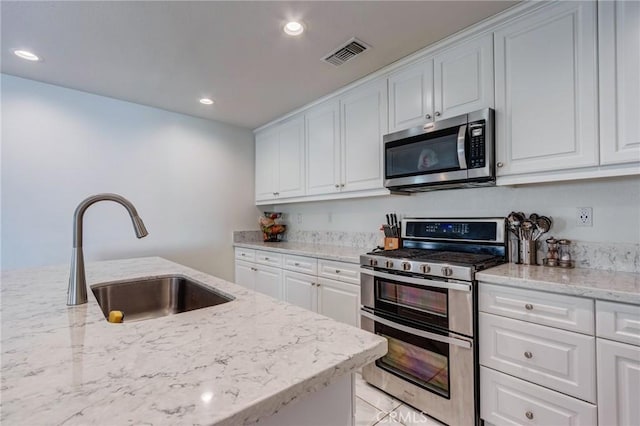 28420 Abbey Ln, Menifee, CA 92585 - kitchen with stainless steel appliances, white cabinets, recessed lighting, and light stone counters