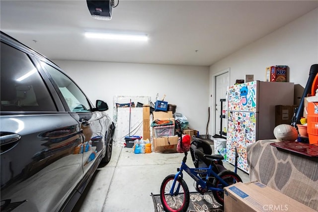 28420 Abbey Ln, Menifee, CA 92585 - garage with a garage door opener and freestanding refrigerator