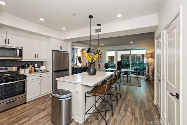 9384 Calm Water Pl, Rancho Cucamonga, CA 91730 - kitchen with appliances with stainless steel finishes, a kitchen breakfast bar, white cabinets, light countertops, and recessed lighting
