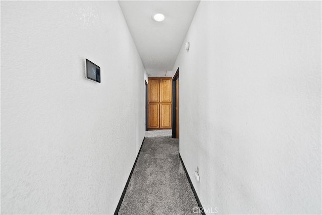 18969 Shoshonee Rd, Apple Valley, CA 92307 - hallway featuring dark carpet and baseboards