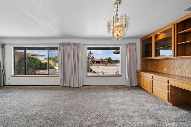 18969 Shoshonee Rd, Apple Valley, CA 92307 - unfurnished living room with light carpet, a textured ceiling, and a chandelier