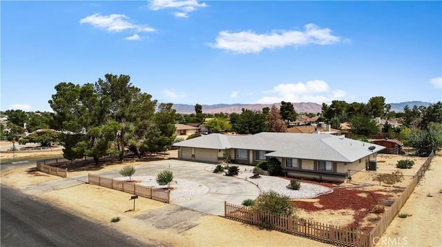 18969 Shoshonee Rd, Apple Valley, CA 92307 - ranch-style house featuring a fenced front yard, curved driveway, a mountain view, and a garage