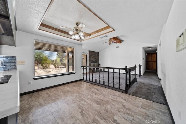 18969 Shoshonee Rd, Apple Valley, CA 92307 - empty room with a ceiling fan, lofted ceiling, a textured ceiling, and a stone fireplace