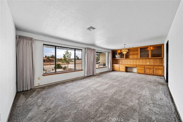 18969 Shoshonee Rd, Apple Valley, CA 92307 - unfurnished living room featuring carpet floors, a textured ceiling, and a chandelier