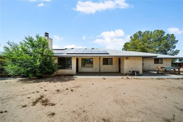 18969 Shoshonee Rd, Apple Valley, CA 92307 - back of house with roof mounted solar panels, a chimney, and stucco siding