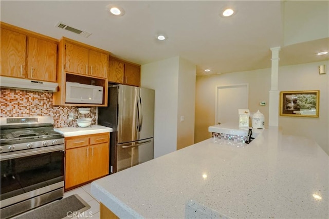 3376 Hackamore Ln, Chico, CA 95973 - kitchen featuring appliances with stainless steel finishes, under cabinet range hood, light countertops, tasteful backsplash, and recessed lighting