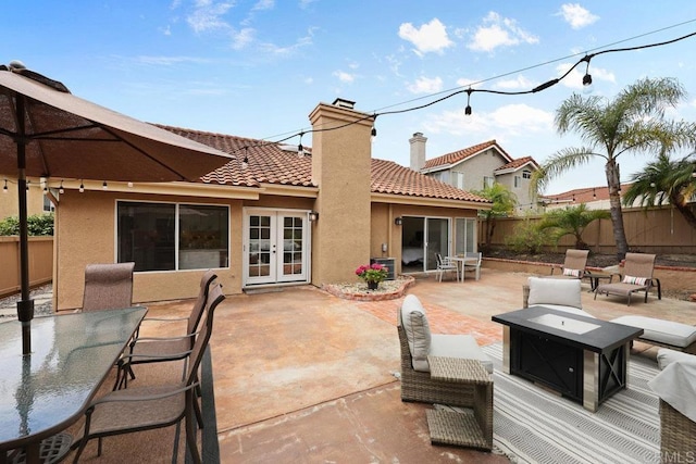 1642 Marbella Dr, Vista, CA 92081 - fenced backyard with french doors, an outdoor fire pit, outdoor dining space, and a patio area