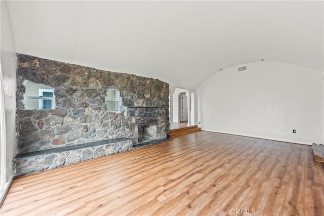 621 S Burris Ave, Compton, CA 90221 - unfurnished living room featuring arched walkways, wood finished floors, a fireplace, and lofted ceiling