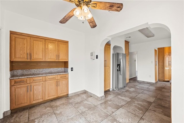 621 S Burris Ave, Compton, CA 90221 - kitchen featuring arched walkways, stainless steel refrigerator with ice dispenser, a ceiling fan, and stone counters