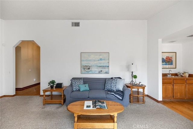 323 N Hacienda Ave, Glendora, CA 91741 - living area featuring arched walkways, bar with sink, and light wood-style flooring