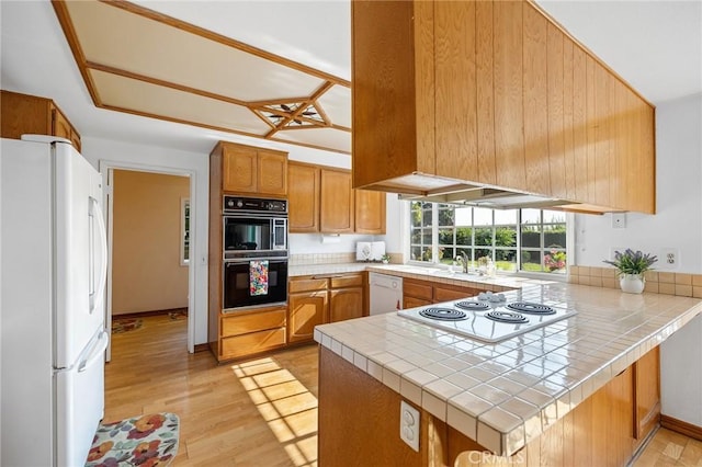 323 N Hacienda Ave, Glendora, CA 91741 - kitchen with white appliances, tile countertops, a peninsula, and light wood-type flooring