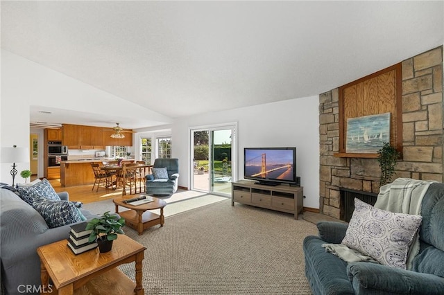 323 N Hacienda Ave, Glendora, CA 91741 - living area featuring ceiling fan, a stone fireplace, and vaulted ceiling