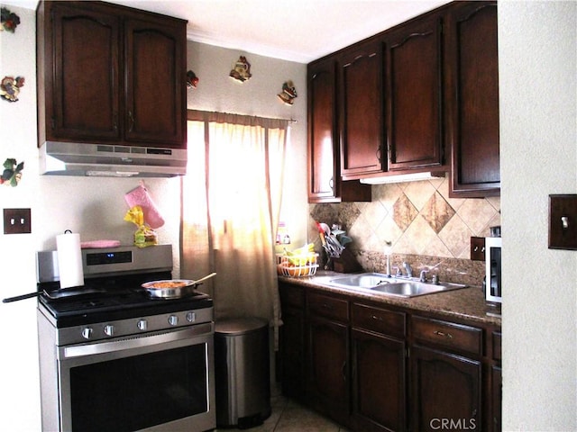 2713 E Monroe St, Long Beach, CA 90810 - kitchen with gas stove, under cabinet range hood, decorative backsplash, dark brown cabinetry, and dark countertops