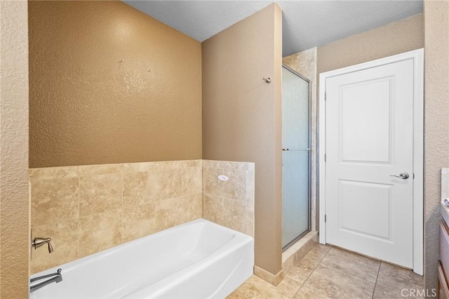 58960 Delano Trl, Yucca Valley, CA 92284 - bathroom featuring a textured wall, a bath, a stall shower, and tile patterned flooring