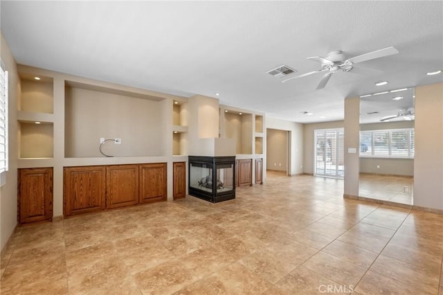 58960 Delano Trl, Yucca Valley, CA 92284 - unfurnished living room with a ceiling fan, a multi sided fireplace, built in shelves, and recessed lighting