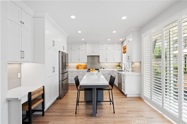 27811 Bloomfield Ct, Valencia, CA 91354 - kitchen featuring stainless steel appliances, backsplash, a breakfast bar, white cabinets, and recessed lighting